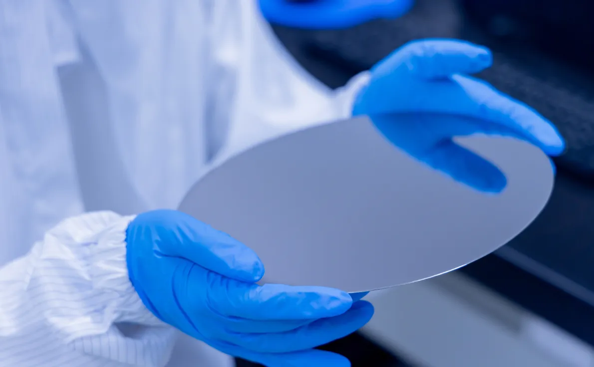 クリーンルームで手袋を着用しシリコンウエハーを扱う様子（検査センター）